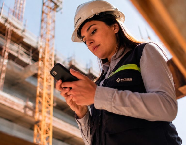 Engenheiro registrando o diário de obras digital pelo celular no canteiro de obras