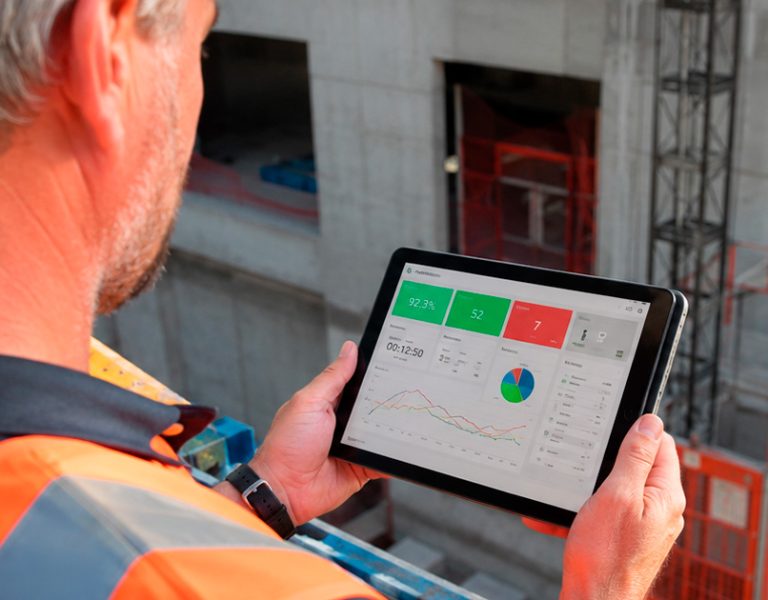 Gestor de construtora analisando indicadores de gestão da construção civil em dashboard de obra no tablet